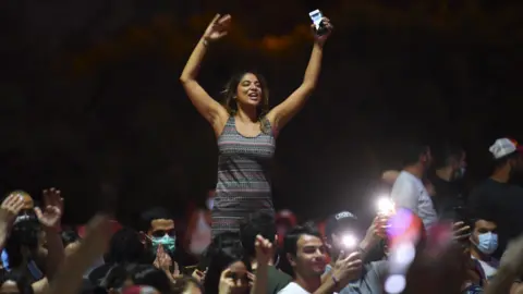 AFP People celebrate in the streets of Tunis after Tunisian President Kais Saied announced the suspension of parliament
