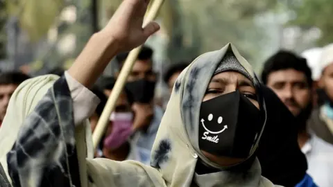 Getty Images Students of Aliah University shout slogan, carry banners as a part of protest against the Hijab (A Muslim Dress) ban in few Karnataka college, Kolkata, India, 09 February,