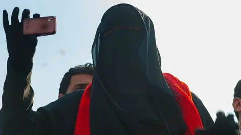 Getty Images A fully veiled girl takes picture with her smartphone in Tahrir Square in Cairo during the uprising to oust president Mubarak