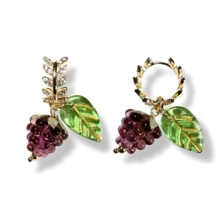 A pair of earings. The huggie-style hoop has diamante leaves and the pendant is a bunch of blackberries and a green leaf with gold detail.