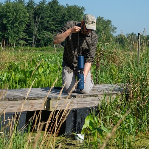 Scientist uses 3D water sensor near water.