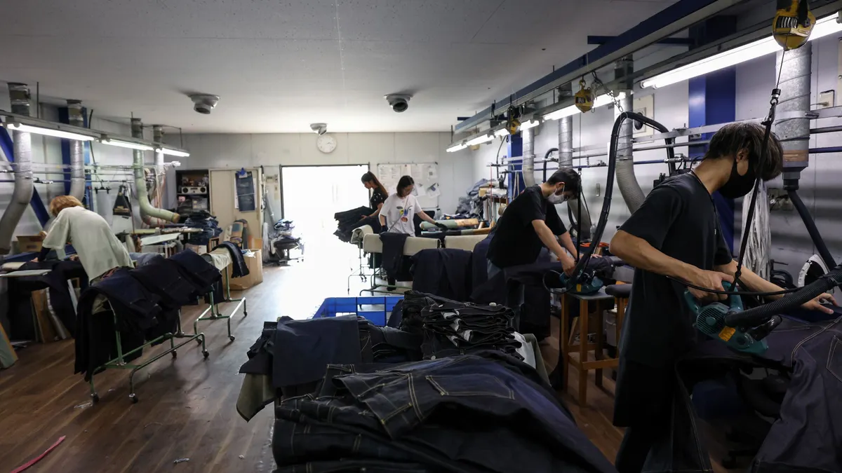 Employees work at a jeans factory.