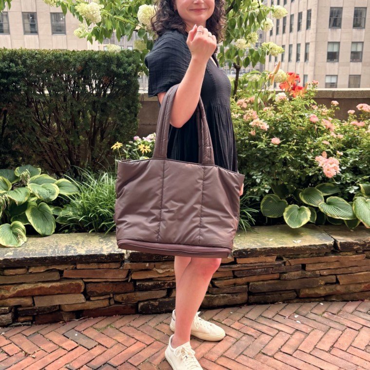 Woman holding the Luka Expandable Tote on right arm.