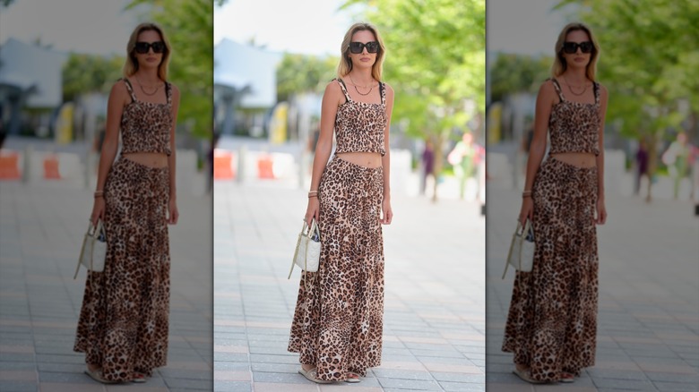 A woman wearing a leopard two piece with sunglasses