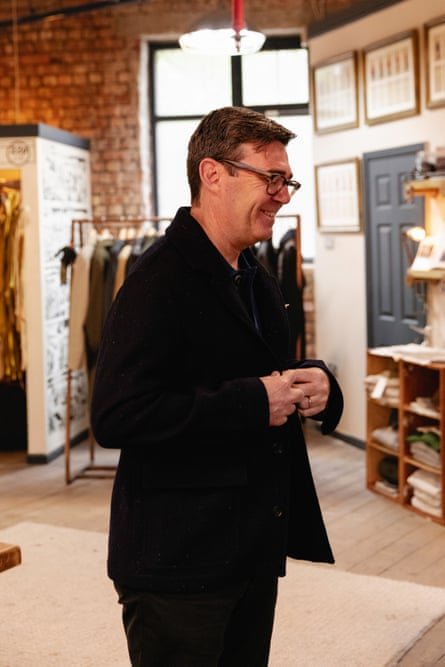 A smiling Andy Burnham tries on a black Private White VC jacket