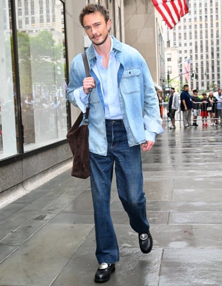 Drew Starkey walking on a pavement in New York City.