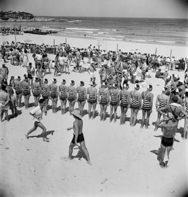 Black and white photograph of crowds at the beach, while lifesavers compete in a surf carnival
