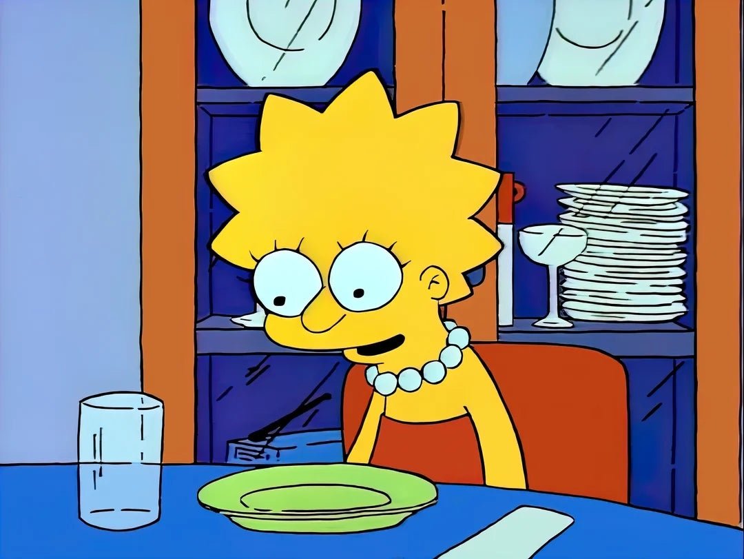 Lisa Simpson sits at a dining table with an empty plate and a glass, looking contemplative. Plates and glasses are seen in the background