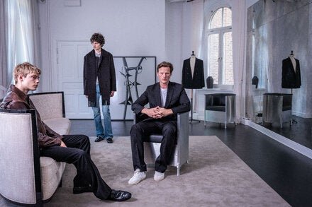 The Toteme co-founder Karl Lindman (right), photographed with two models at the brand’s Stockholm headquarters on June 9, 2026, wearing pieces from his debut men’s wear collection.